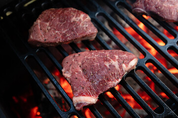 Beef rumpsteak cooked on a cast iron grate on a charcoal grill