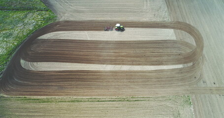 Tractor plowing field. Farmer working on wheat field.