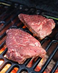 Beef rumpsteak cooked on a cast iron grate on a charcoal grill