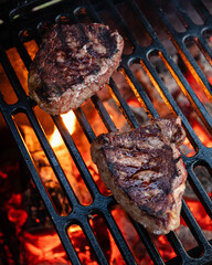 Beef rumpsteak cooked on a cast iron grate on a charcoal grill