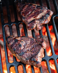 Beef rumpsteak cooked on a cast iron grate on a charcoal grill