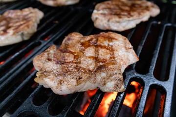Pork chop cooked on a charcoal grill on a cast iron grate