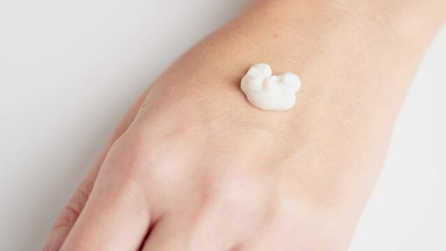 Creamy scrub falling at the woman's hand. Cosmetology, hand care, spa cosmetics, beauty concept