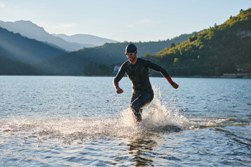 Triathlon athlete starting swimming training on lake