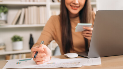 Beautiful young woman using laptop while working in home office. Businesswoman happy and smiling at indoors.