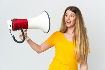 Young blonde woman isolated on white background holding a megaphone with stressed expression