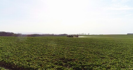 Tractor spray fertilize on field with chemicals in agriculture field.