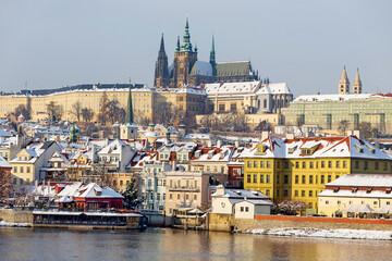 Snowy Prague Lesser Town with gothic Castle above River Vltava, Czech republic