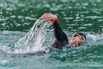 A professional triathlete trains with unwavering dedication for an upcoming competition at a lake,...