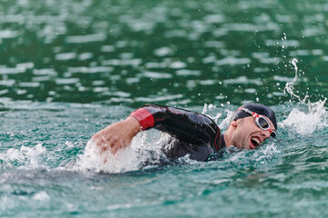 A professional triathlete trains with unwavering dedication for an upcoming competition at a lake,...