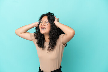 Young asian woman isolated on blue background stressed overwhelmed - obrazy, fototapety, plakaty