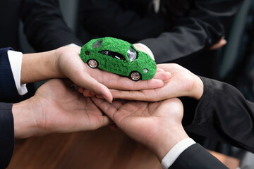 Business people holding EV car model as business synergy partnership unite and take action to...