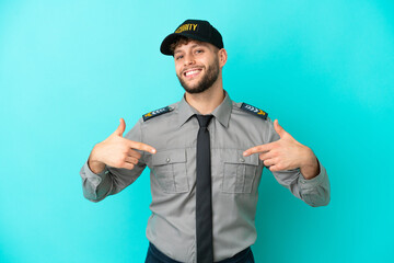 Young security man isolated on blue background proud and self-satisfied