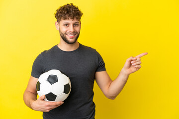 Handsome young football player man isolated on yellow background pointing finger to the side