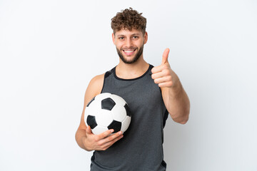 Young handsome caucasian man isolated on white background with soccer ball and with thumb up