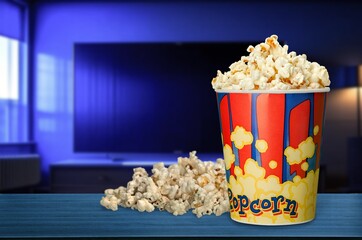 Blank tv screen and popcorn bowl on the desk