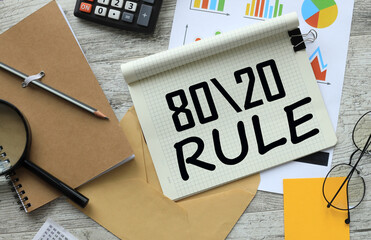 80/20 rule. financial charts and magnifying glass on the desk. text
