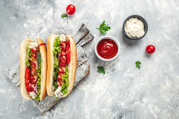 Hot dog with sausage in a bun with sauces on a light background, Fast food menu for kids, top view