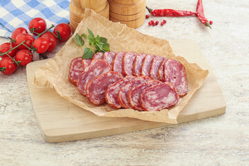 Sliced salami sausages over board