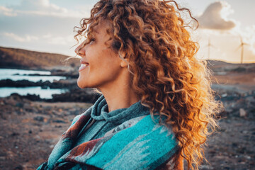 Woman outdoor smiling with long curly beautiful hair enjoying outdoor leisure activity alone. Concept of travel and tourism people. Happiness outdoor leisure activity. Serene lifestyle. Destination