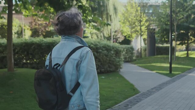 An elderly lady lost in city trying to find her tour group mates outdoors. Grandmother tourist never stop exploring new locations. Lost in town woman turning around and goes away