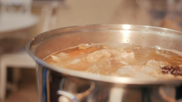Stock simmering on a stovetop in a metal pan 