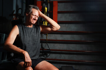 Older Mature senior man at a gym relaxing between reps. Health Concept 