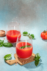 tomato juice with basil and fresh tomatoes on a light background top view. copy space
