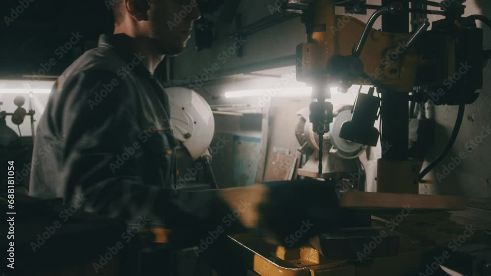 Poster a worker works on a metal drilling machine in a workshop. metallurgy production. a machinist operati