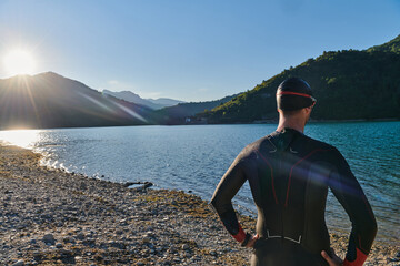 Fototapeta premium Authentic triathlon athlete getting ready for swimming training on lake