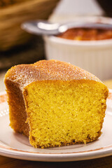 slice of cornmeal cake, traditional homemade corn cake from Brazil in June parties, with rustic sweets in the background