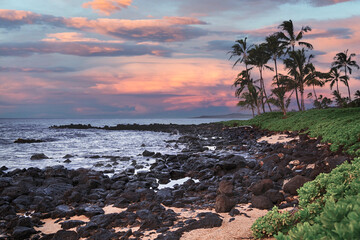 Sunset over rocky beach of Poipu, Kauai