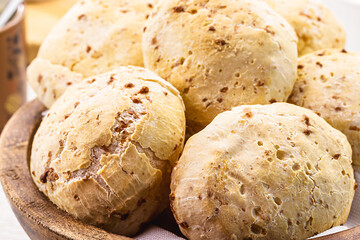 bowl full of traditional brazilian cheese bread or cheese biscuit, served crispy and hot, with coffee