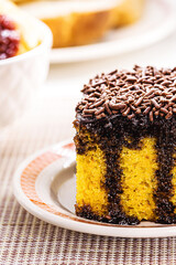 carrot cake with chocolate sprinkles, creamy frosting dripping down the cake, served with latte