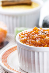 pot with homemade pumpkin jam, typical Brazilian dessert at the June and July parties, in the background fuba cake and candied sweets