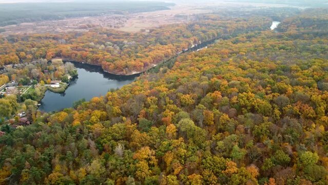 Autumn aerial forward flight above river with scenic colorful forest on riverbanks. Cossack mountain near Koropove village on Siverskyi Donets River in Ukraine