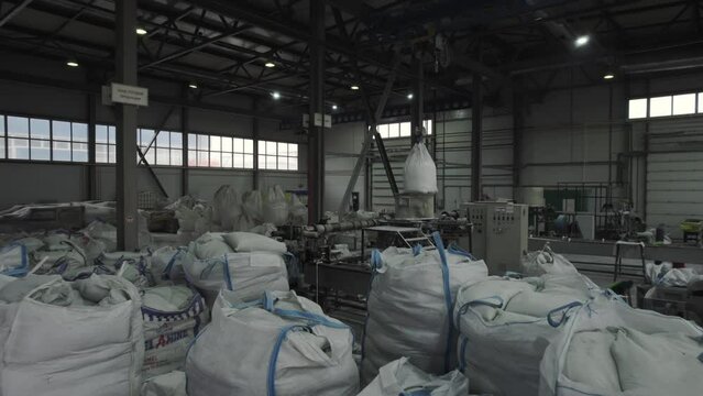 Warehouse stocked with sacks containing raw components. Satchels filled with recycled materials set for chemical fertilizer transformation