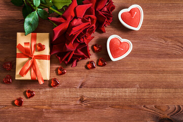 Valentines day frame with gift box and red roses, candles  on a wooden background. Valentines day banner with copy space