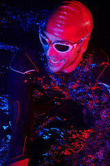 authentic triathlete swimmer having a break during hard training on night neon gel light