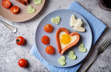 Fresh breakfast with fried sausage with fried egg in the form of heart for Valentine's day holiday