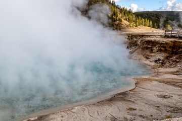 excelsior geyser crater, a dormant geyser and steaming hot spring on a cold cloudy day and letting...