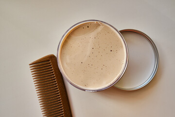 Clay, pomade, wax, gel or mousse in a round metal box for hair styling. Advertising concept for...