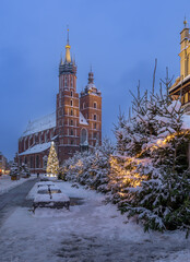 Krakow, Poland, snowy Main Market square, and St Mary's church in the winter season, during Christmas fairs decorated with Christmas tree - 688193072