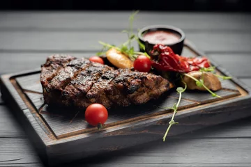 Foto op Canvas Grilled pork steak and vegetables on rustic wooden table © mtrlin