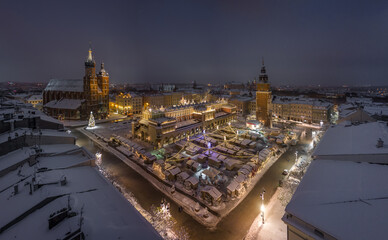 Night view of snow covered Main Square with Christmas Fairs in Krakow, Poland