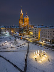 St Mary's church and Christmas tree on the snow covered Main Square in the winter night, Krakow, Poland