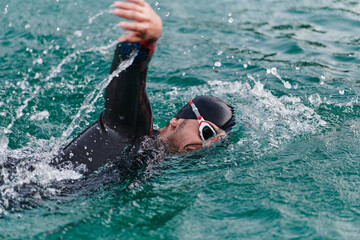 A professional triathlete trains with unwavering dedication for an upcoming competition at a lake, emanating a sense of athleticism and profound commitment to excellence.