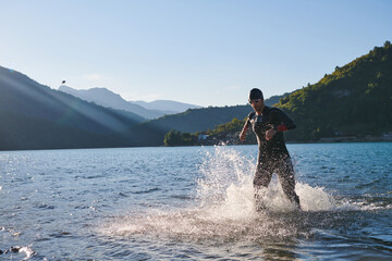 Triathlon athlete starting swimming training on lake