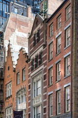 Fototapeta na wymiar New York City, NY, USA, Low angle view of some of the historic buildings on Stone Street of former New Amsterdam in Manhattan with modern high rise in the background