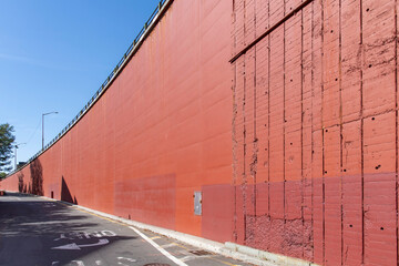 Image filling view of the curved concrete red colored façade and ramp of the Brooklyn-Queens...